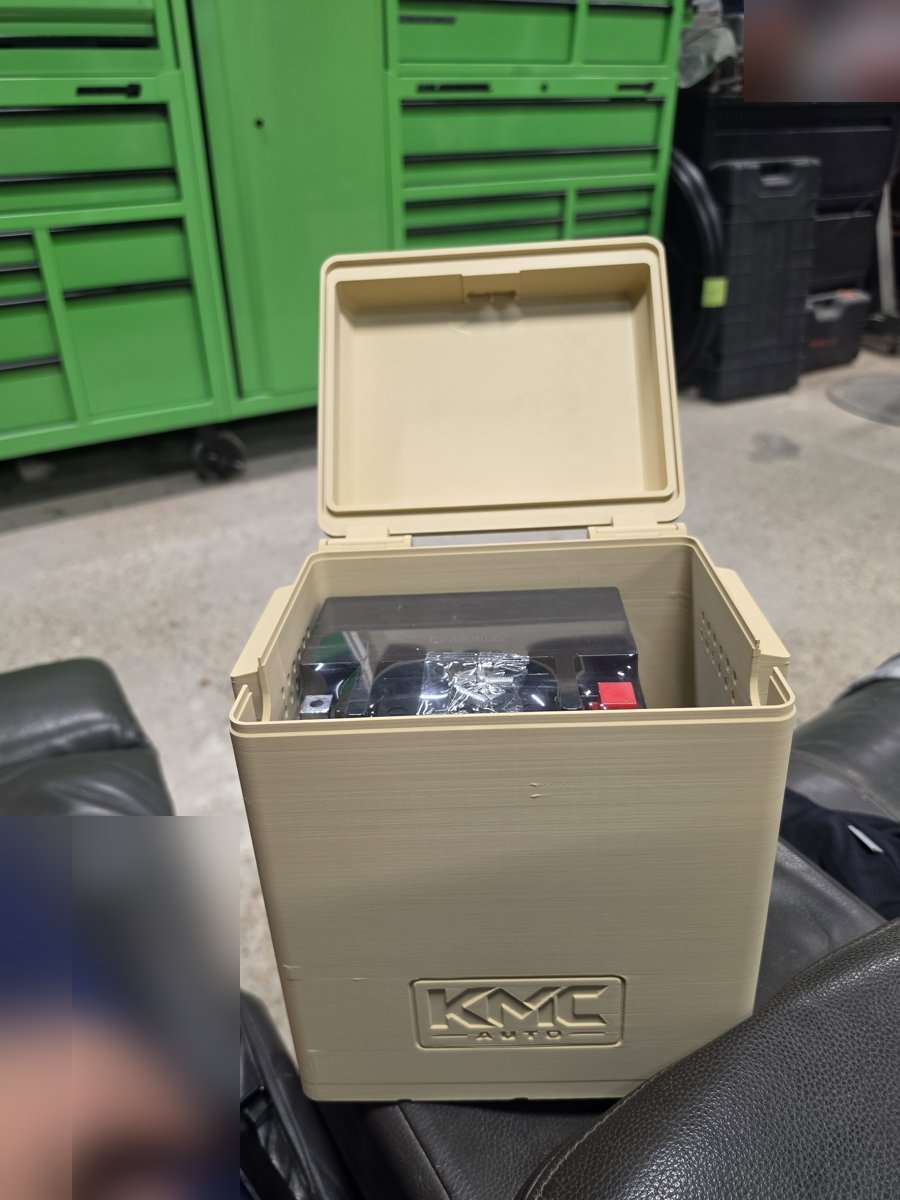 KMC-branded battery box with the hinged lid open and the battery inside